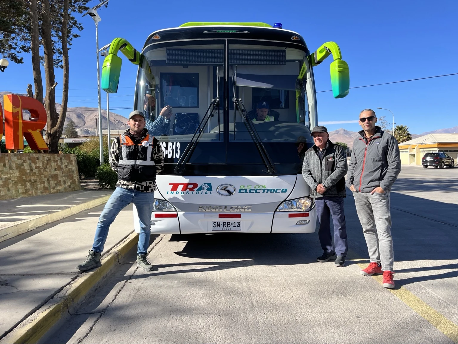 Los tres propietarios de TRA junto a un bus de la empresa